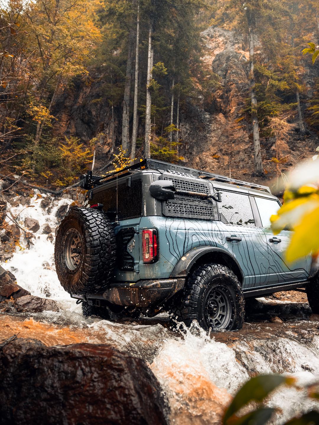 Truck on an overland trail featuring WildWrap topographic vinyl decals on body panels