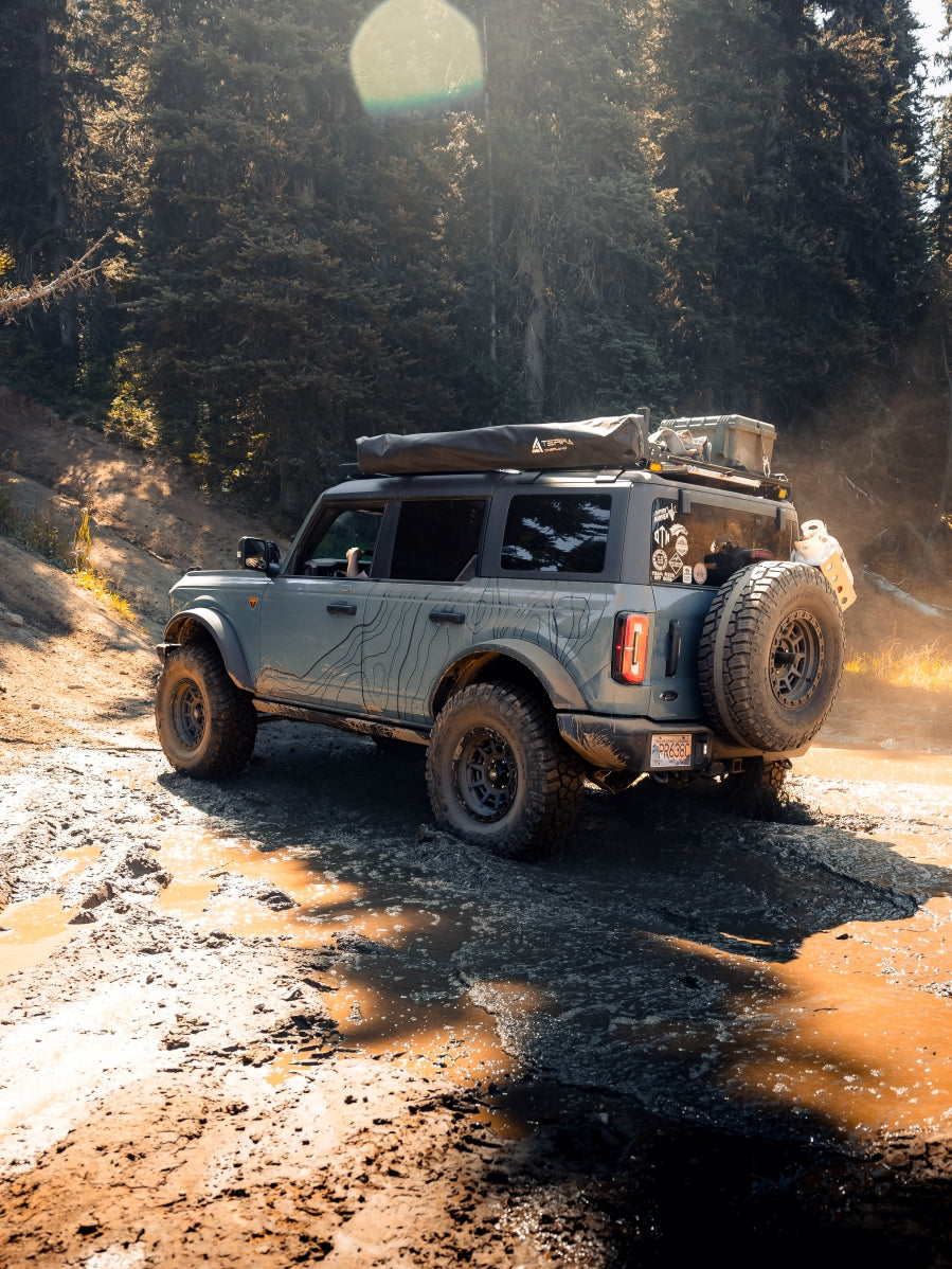 Off-road truck on a forest road with a topographic vinyl decal pattern installed